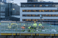 Jobbare på Hisingsbron. I bakgrunden syns en kontorsfastighet och i fönstren har man pyntat med ljusstakar.