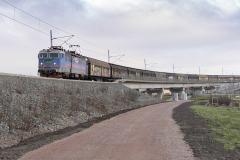 Hamnbanan går parallellt med Partihallsförbindelsen. Ett långt godståg är på väg mot Göteborgs Hamn.