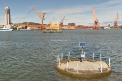 Här står en solcell på något betongfundament i vattnet.