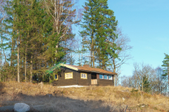 En liten sommarstuga finns kvar en stund till på kullen där Örnåsvägen ringlar tunt kullen.